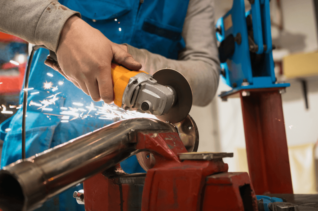 Technician Cutting Metal WithMany Sharp Sparks Equipm